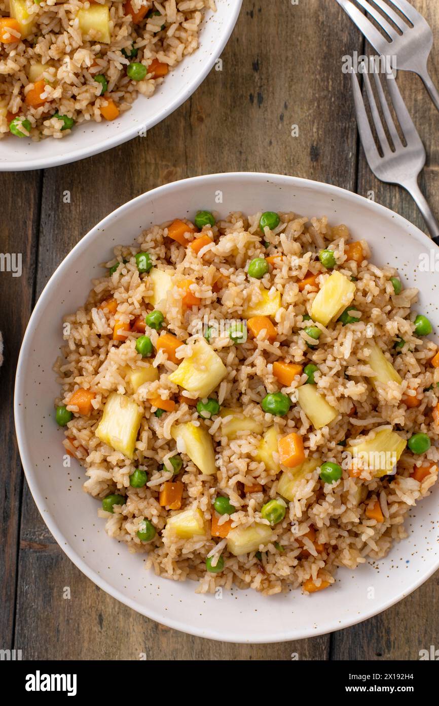 Vegan fried rice with pineapple, carrots and peas, balanced vegan meal idea Stock Photo