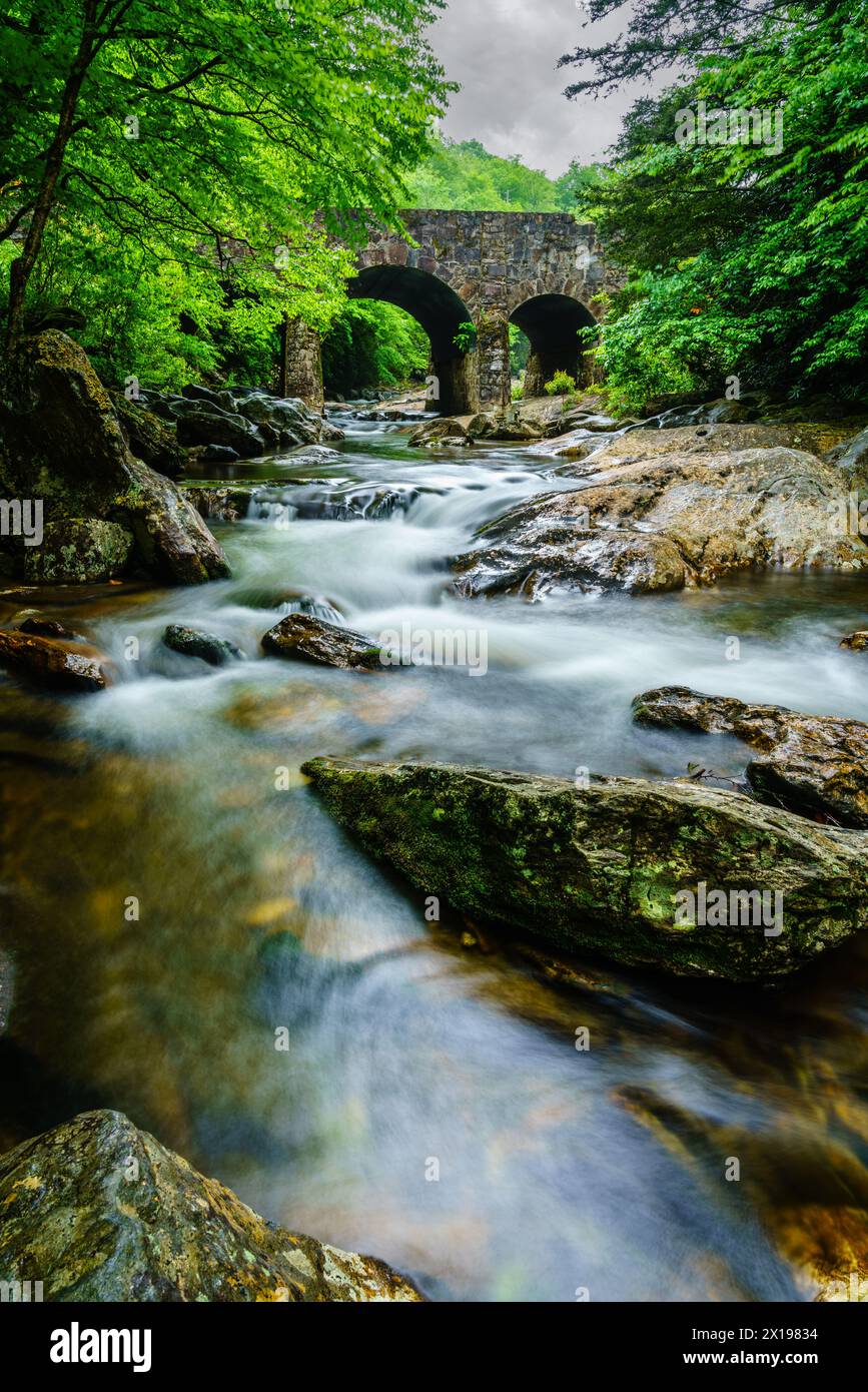 Long exposure image of West Fork Pigeon River under Tripple Arch Bridge near Maggie Valley, North Carolina. Stock Photo