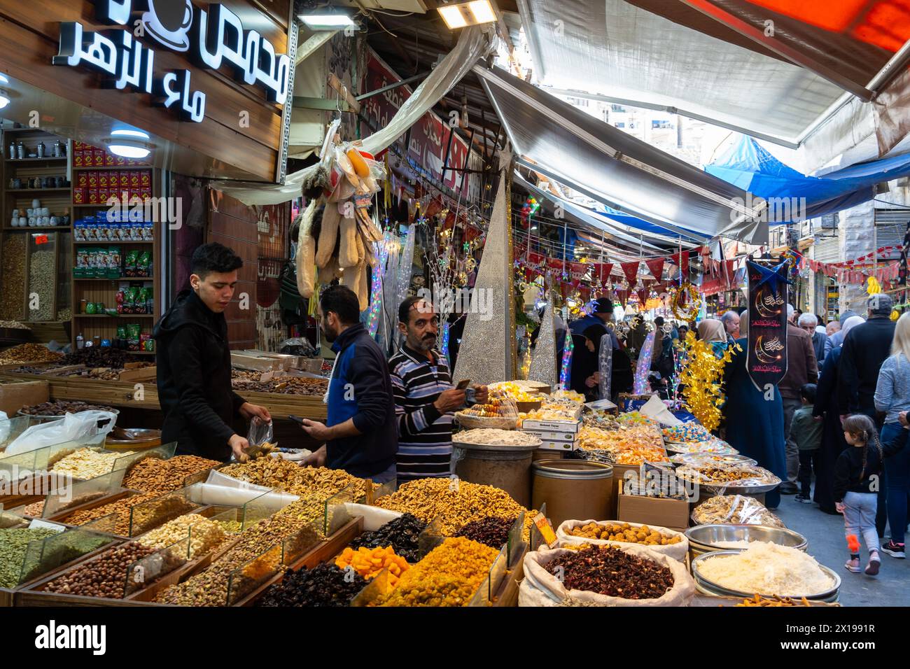 Amman, Jordan - March 14 2023: People shops in the traditional Souq Al-Sukar for fresh seeds and nuts in the old town and historic district of Jordan Stock Photo