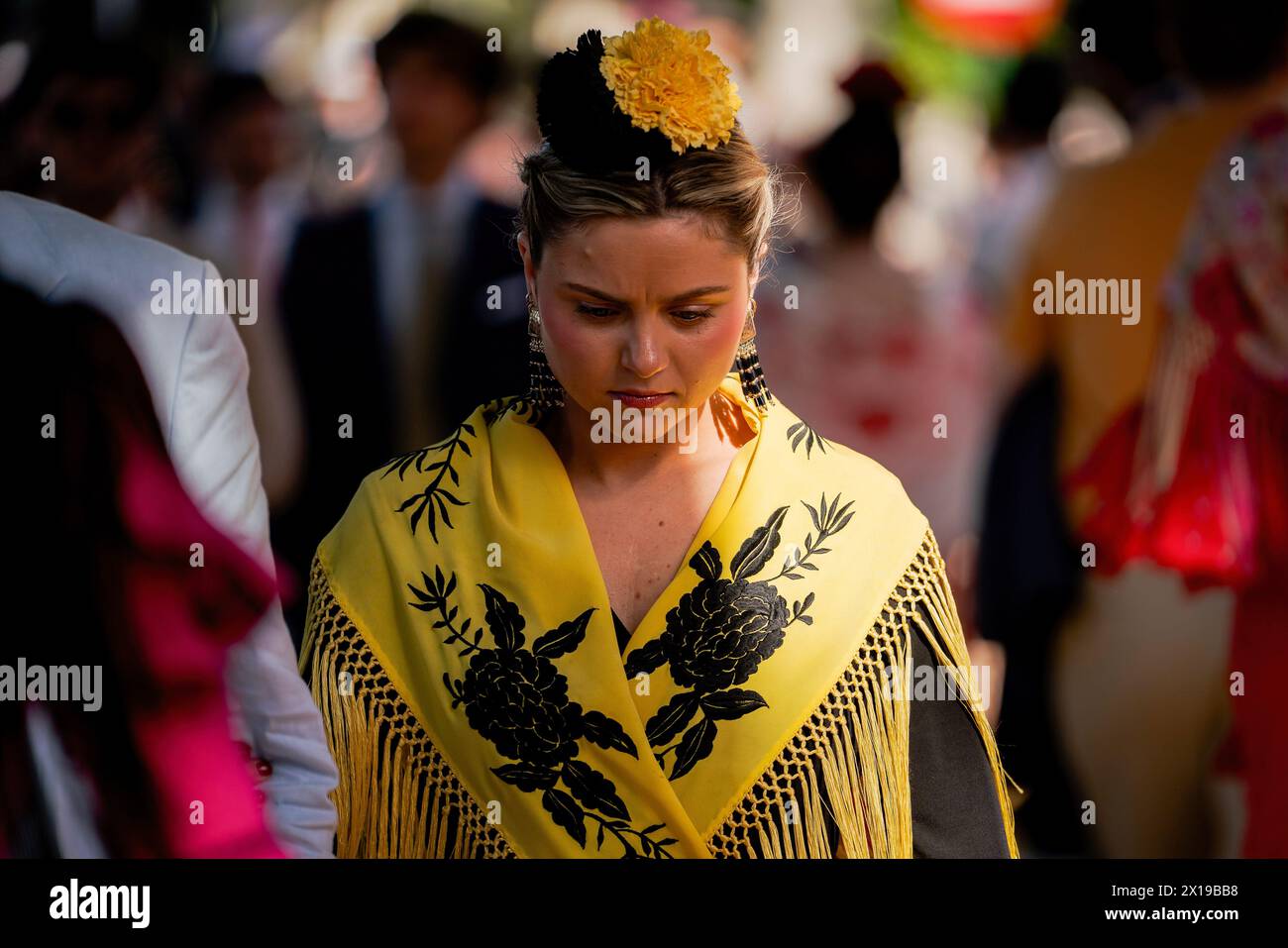 A woman wearing the traditional flamenco dress, often in bright colors, and accessorized with a flower in the hair is seen during the fair. The April Fair is one of the most international and popular festivals in Seville. Created in 1847 as a livestock fair, over time the festive aspect of the event ended up taking over the commercial part, until it became an essential event for Sevillians. For a week, more than a thousand booths installed in the fairgrounds became the second home of the inhabitants of this city, a space where they can share and have fun in company until the early hours of the Stock Photo