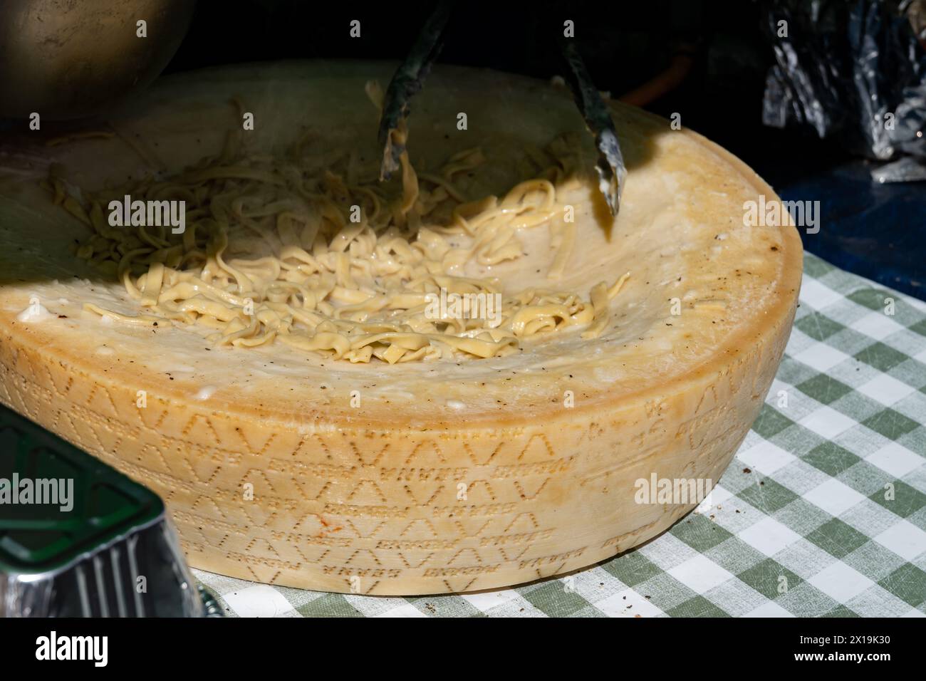 Italian food, cooking fresh homemade pasta tagliatelle in big wheel of