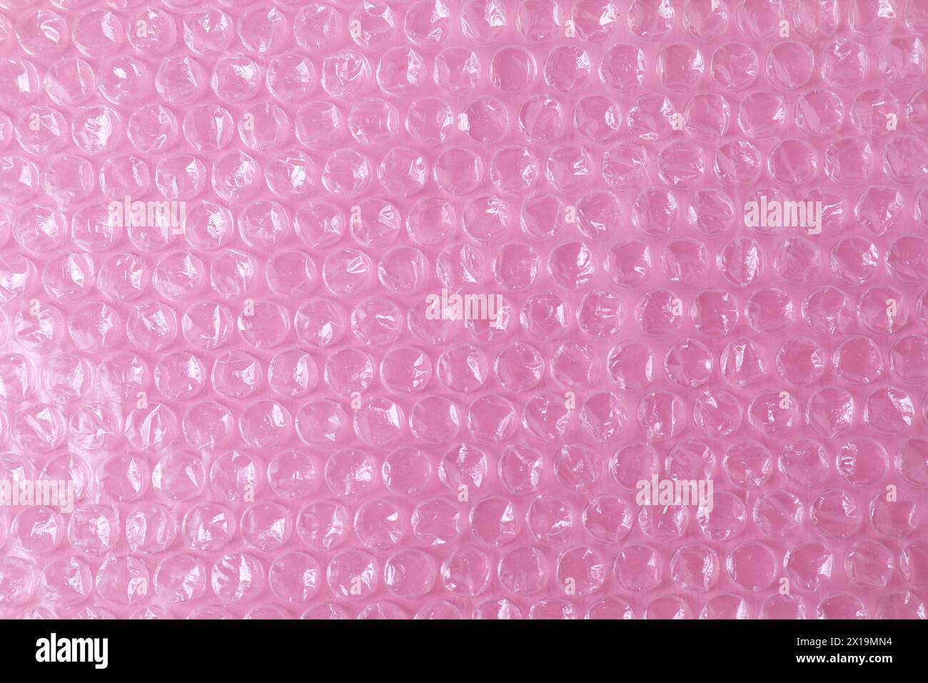 Transparent bubble wrap on pink background, top view Stock Photo