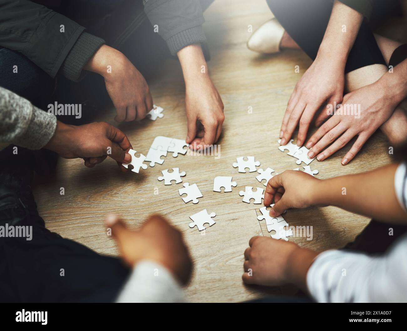 People, teamwork and hands with puzzle on floor for problem solving ...
