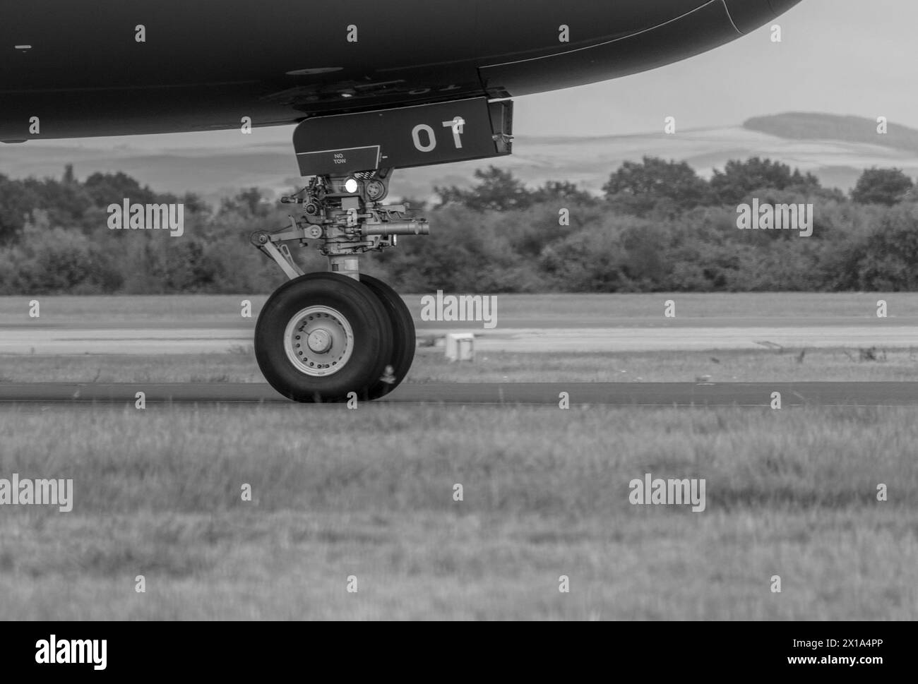 Close up Black & White of the front landing gear of a plane taxing. Stock Photo