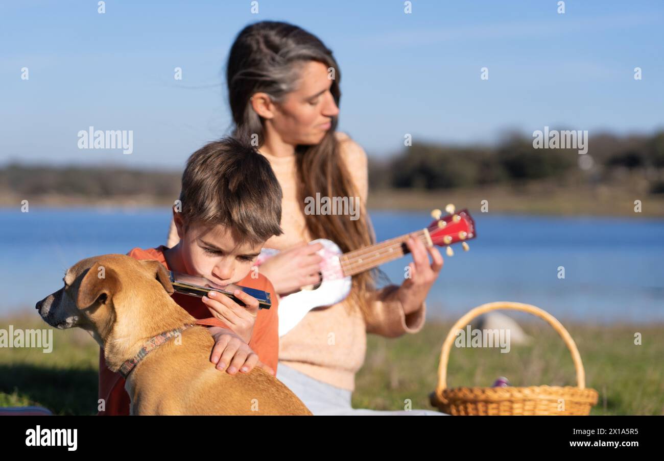 Caucasian family of mother, son and their dog having a picnic and ...