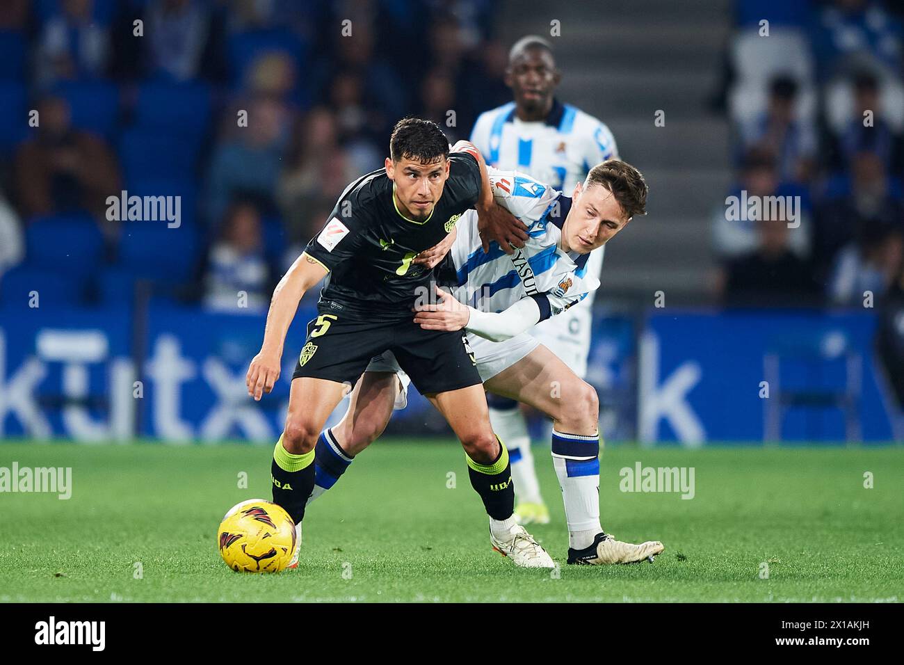 Lucas Robertone of UD Almeria compete for the ball with Benat Turrientes of Real Sociedad during the LaLiga EA Sports match between Real Sociedad and Stock Photo