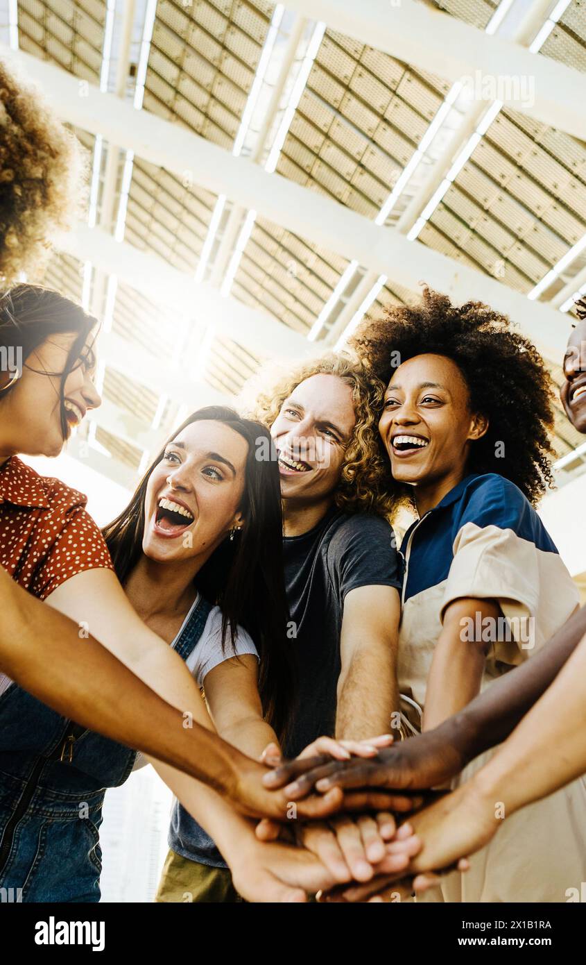 Multiracial happy friends with hands in stack Stock Photo