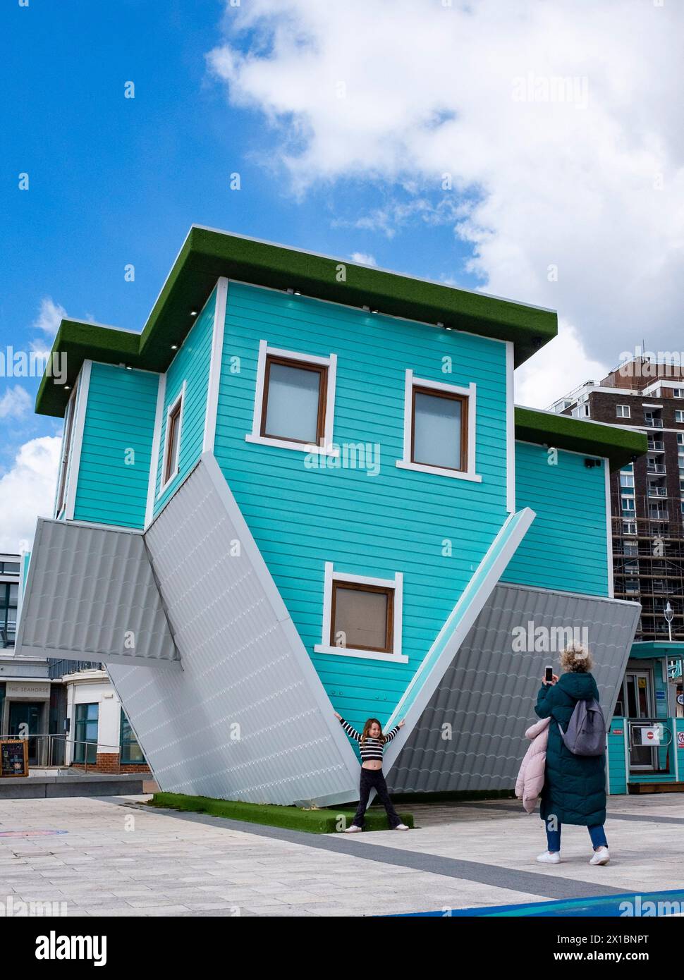 Young girl of 7 years of age visiting the Upside Down House tourist attraction on Brighton seafront , Sussex , England UK Stock Photo