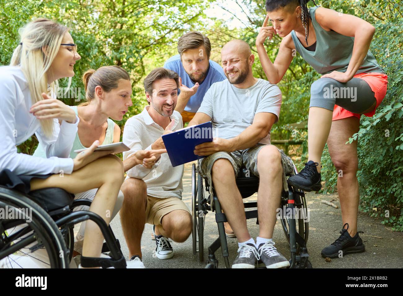 A diverse group of friends enjoys time outdoors, including a person using a wheelchair and another with a prosthetic leg, embodying inclusion and posi Stock Photo