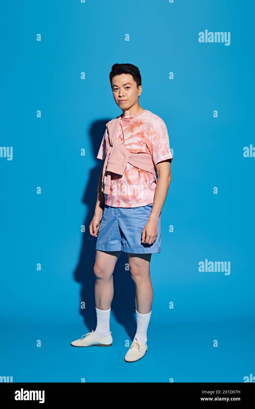 A trendy young man striking a dynamic pose in stylish attire against a ...