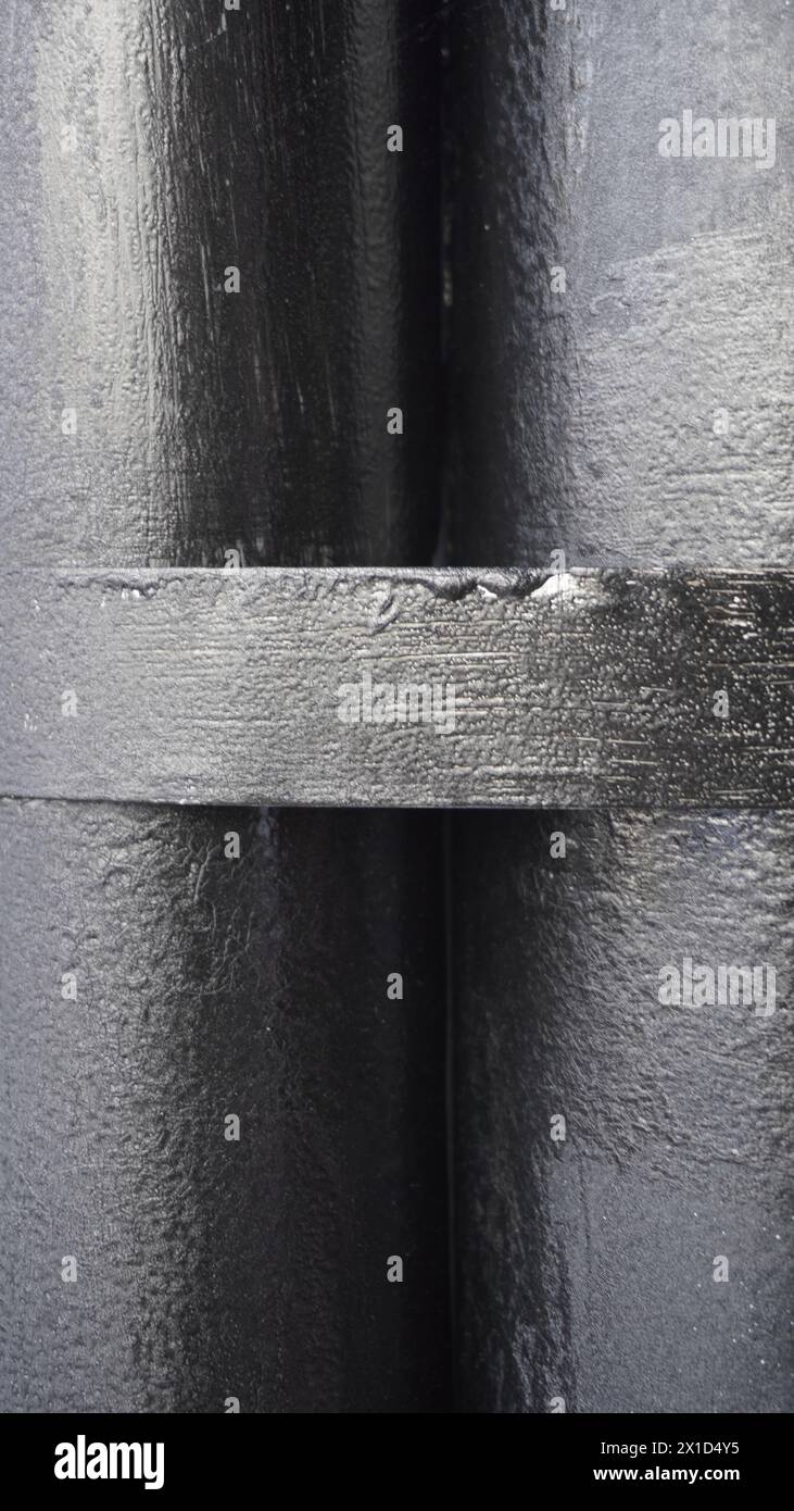 Two black pipes stick together background Stock Photo