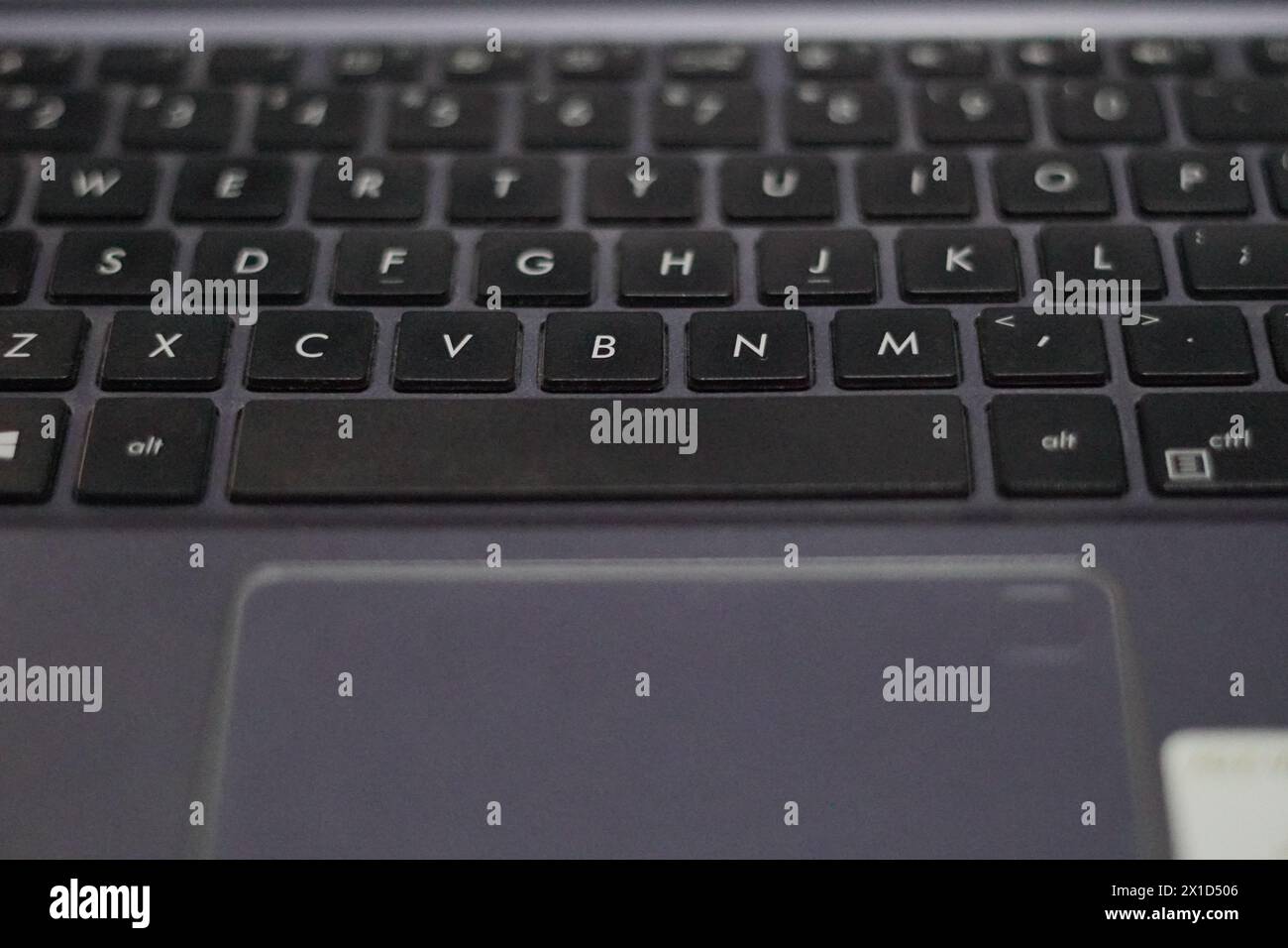 A black laptop keyboard with a tracking pad that has a fingerprint Stock Photo