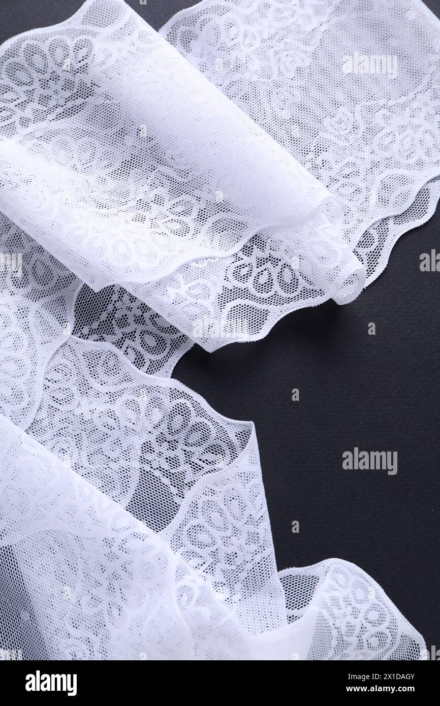 White lace on black background, top view Stock Photo