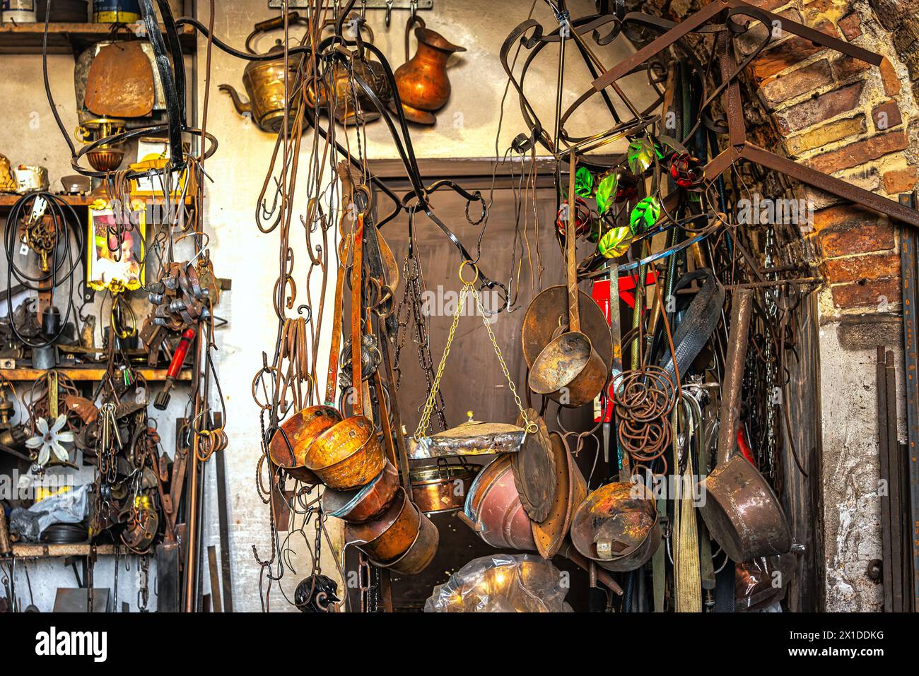 The interior of a master blacksmith's workshop with hanging objects in wrought iron and copper. Guardiagrele, Chieti province, Abruzzo, Italy, Europe Stock Photo