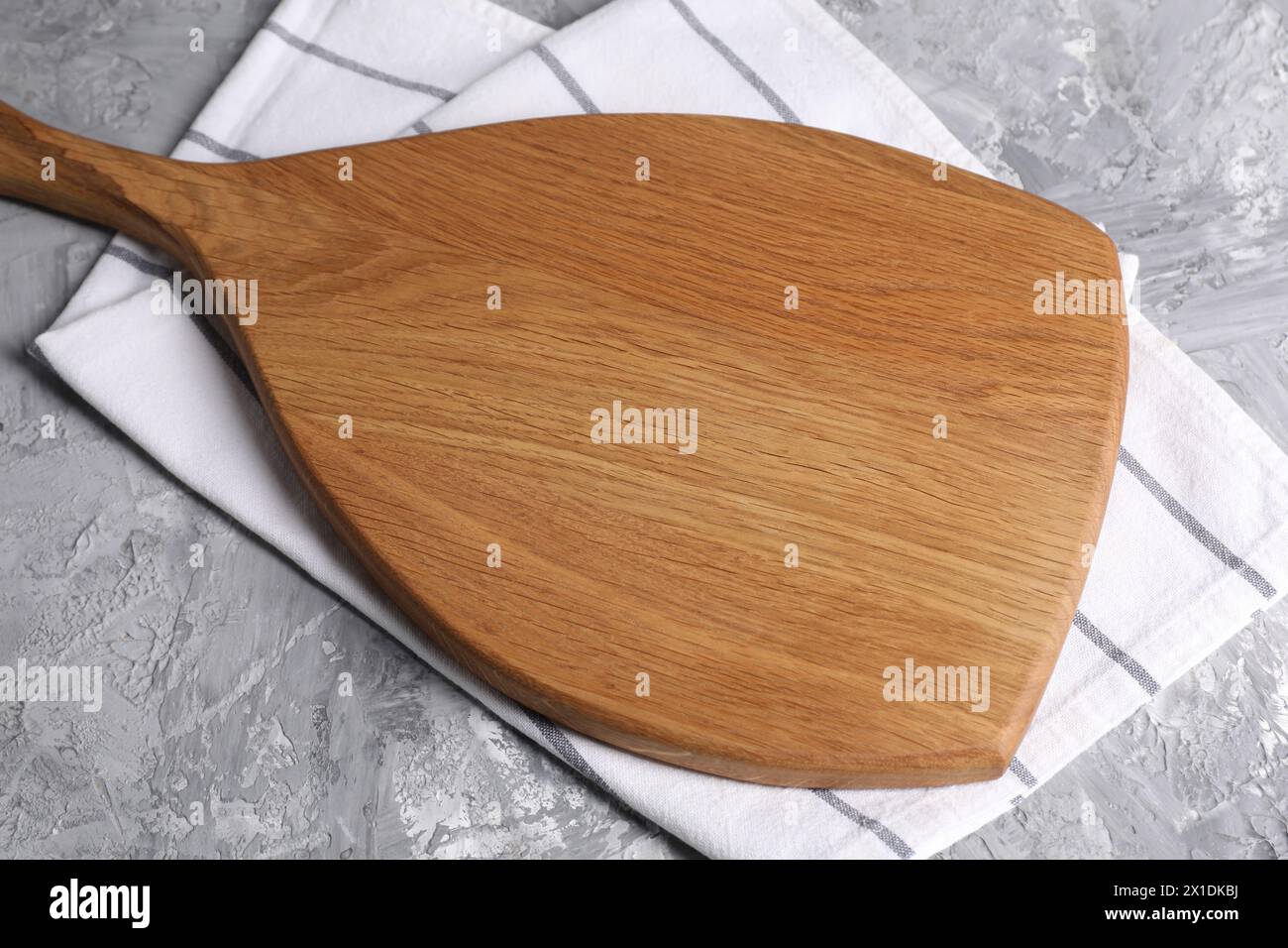 Wooden cutting board and napkin on grey table Stock Photo