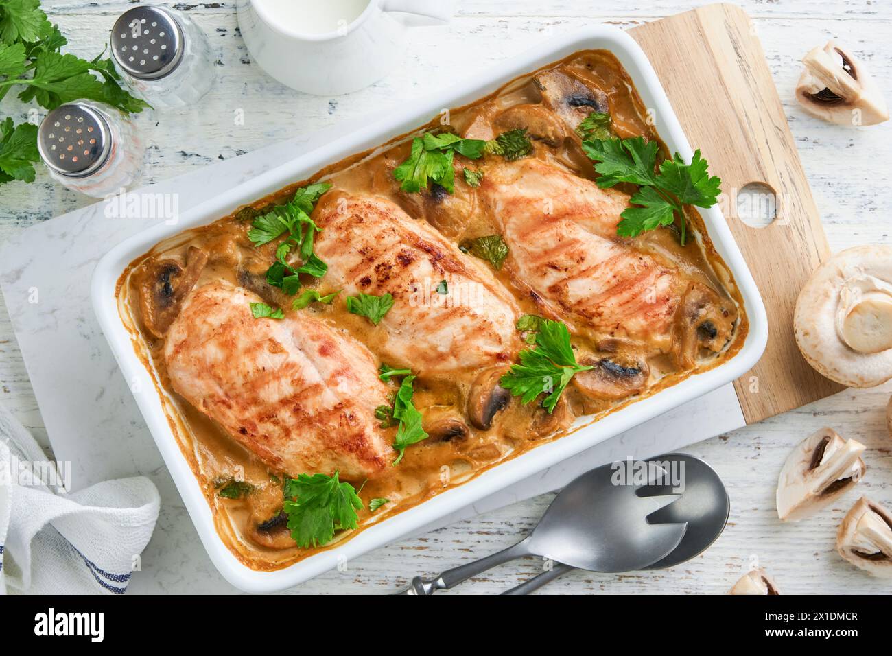 Baked chicken breast bbq with mushrooms and garlic in cream sauce on white wooden table backgrounds. Top view image with ingredients for cooking. Top Stock Photo