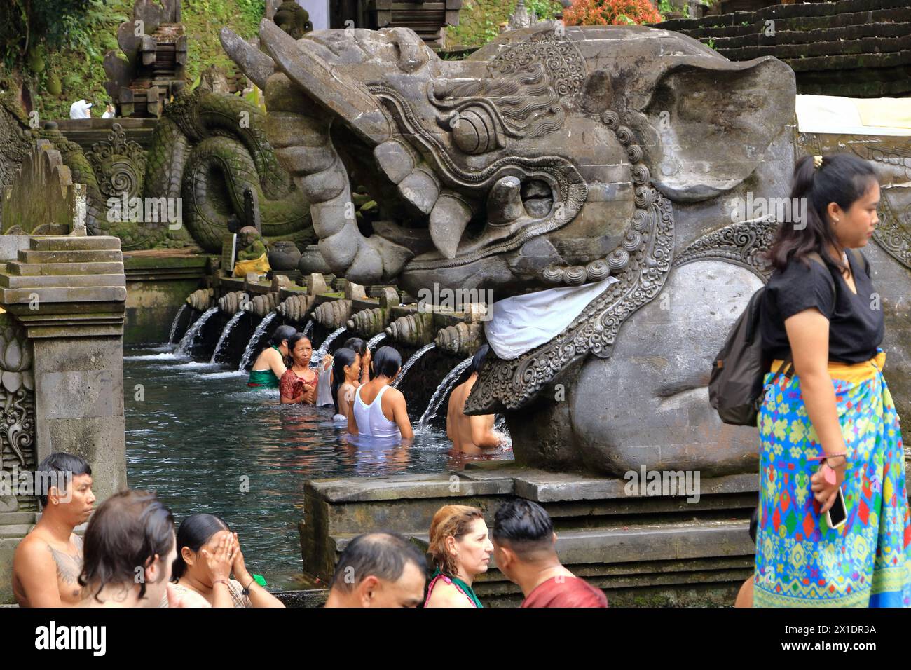 Tampak Siring, Tampaksiring, Bali in Indonesia - January 31 2024: people take a bath in the Tirta Empul temple (Holy Spring Water Temple) Stock Photo