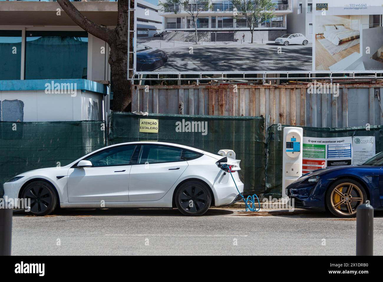 Tesla brand vehicle charging its batteries at a charging point or electric station on a sunny day in the city of Lisbon Stock Photo