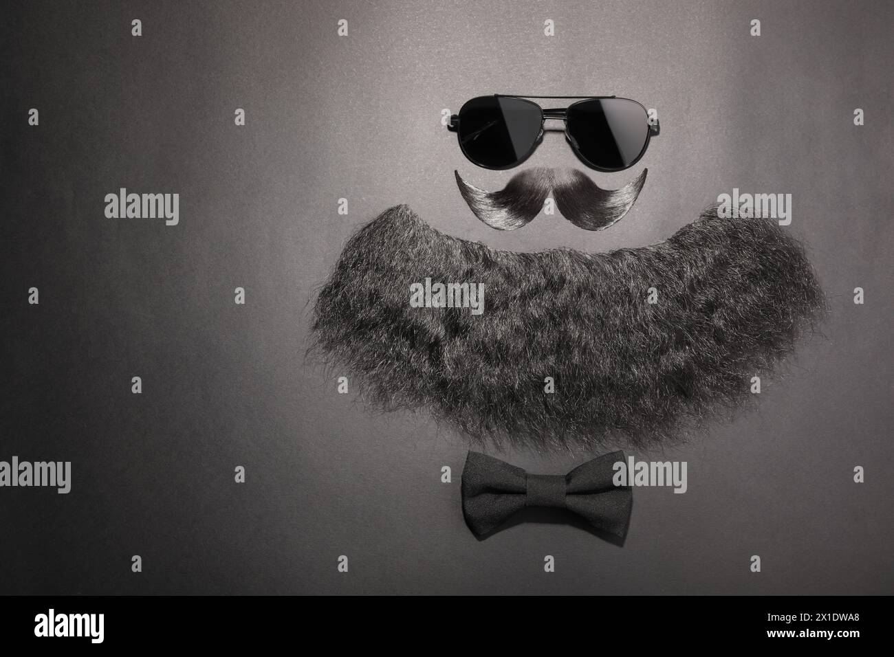 Flat lay composition with artificial moustache and sunglasses on black background, space for text Stock Photo