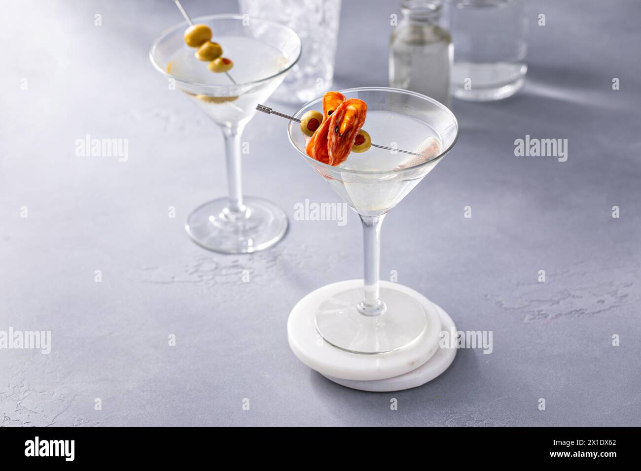 Martini with olive and salami garnishes, dirty martini cocktail in a traditional glass Stock Photo