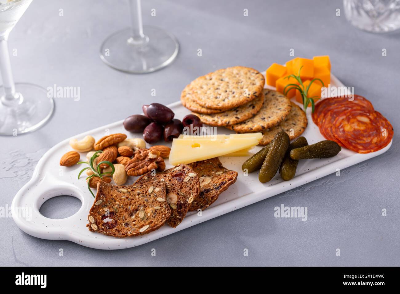 Small charcuterie or cheese board for two served with martinis Stock Photo