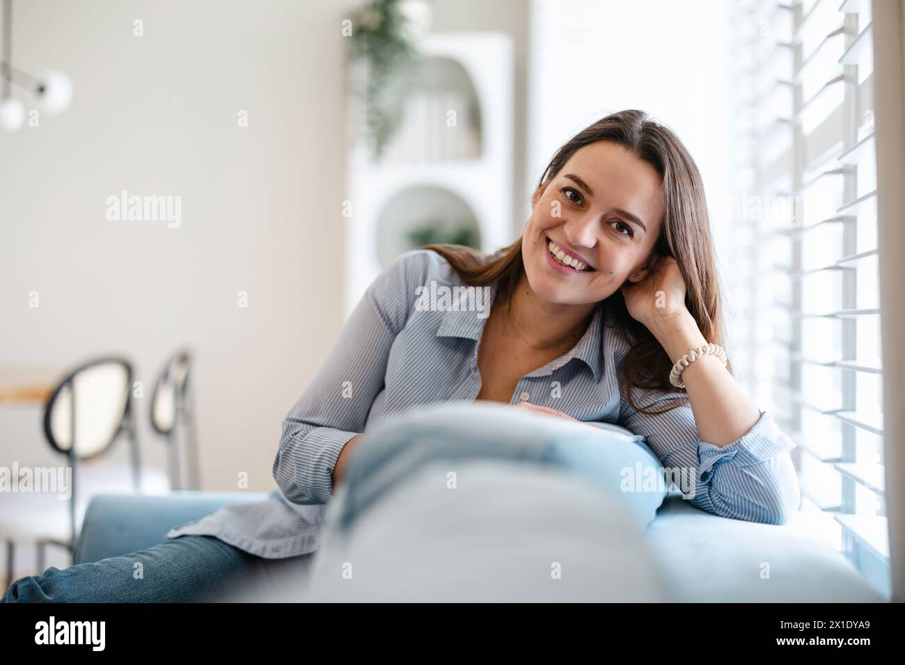 Casual woman sitting on sofa hi-res stock photography and images - Alamy