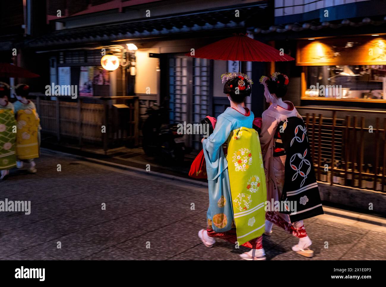 Japan - Geishas walk home in the evening in Kyoto's entertainment district wearing traditional kimonos Stock Photo