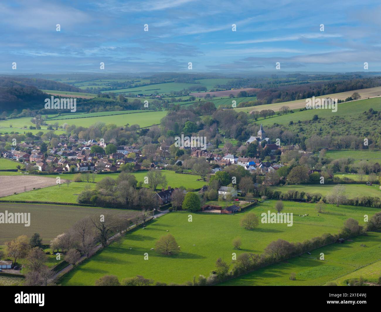 The village of East Meon nestling in the South Downs in the Hampshire countryside. Aerial view centred on All Saints Church to the North. Stock Photo