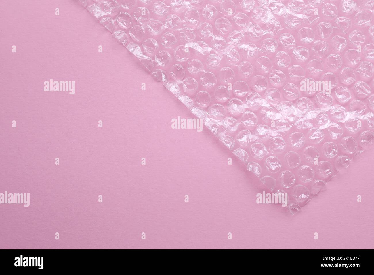 Transparent bubble wrap on pink background, top view. Space for text Stock Photo