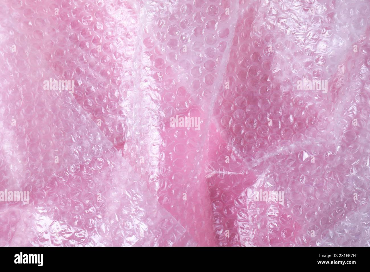Transparent bubble wrap on pink background, top view Stock Photo