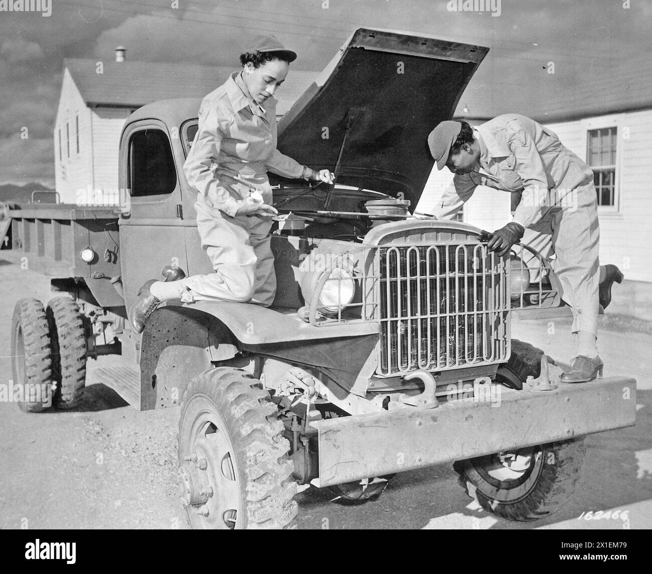 Auxiliaries Ruth Wade and Lucille Mayo (left to right) further demonstrate their ability to service trucks as taught them during the processing period at Fort Des Moines and put into practice at Fort Huachuca, Arizona ca. 1942 Stock Photo