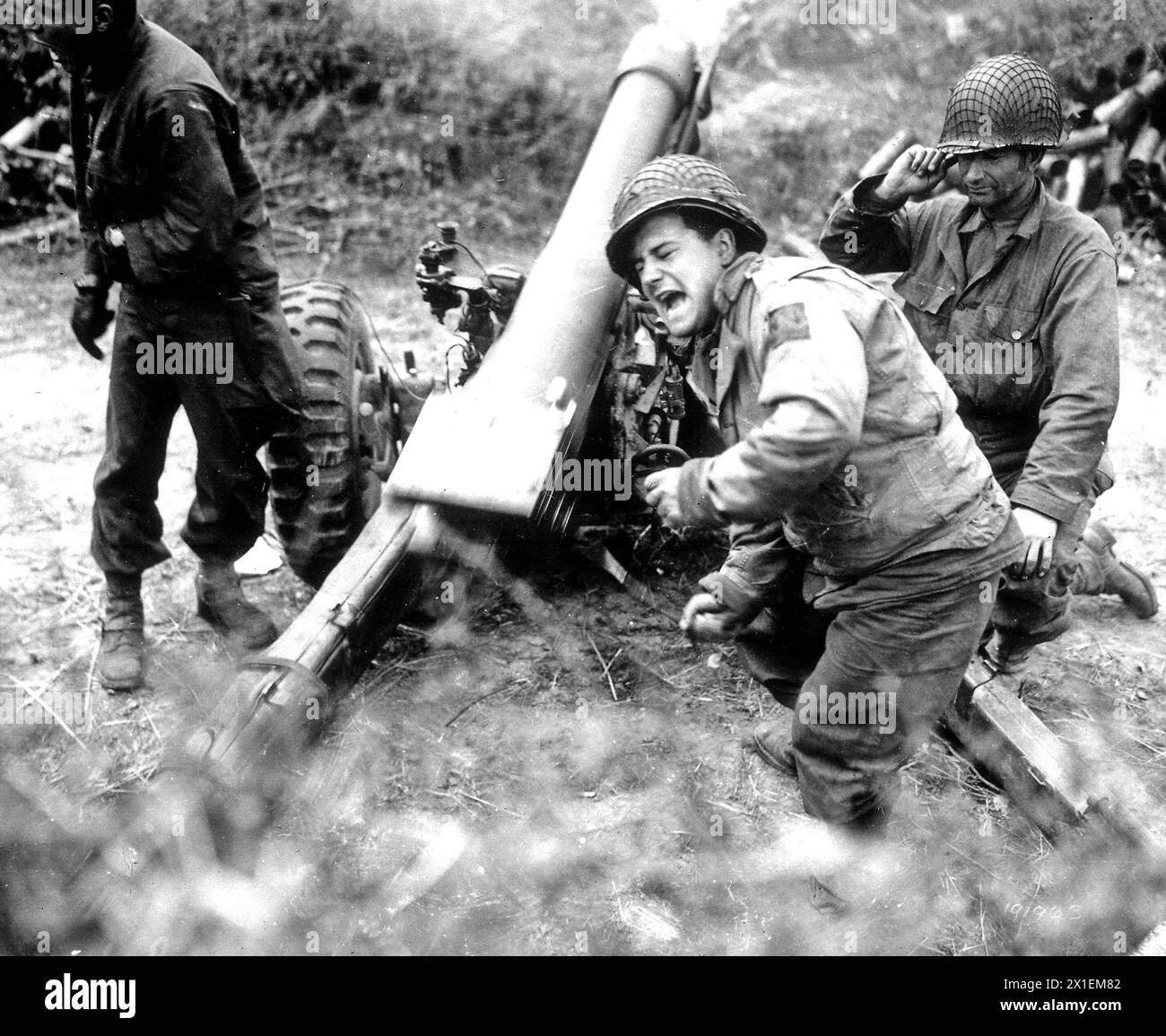 American howitzers shell German forces retreating near Carentan, France ca. 1944 Stock Photo