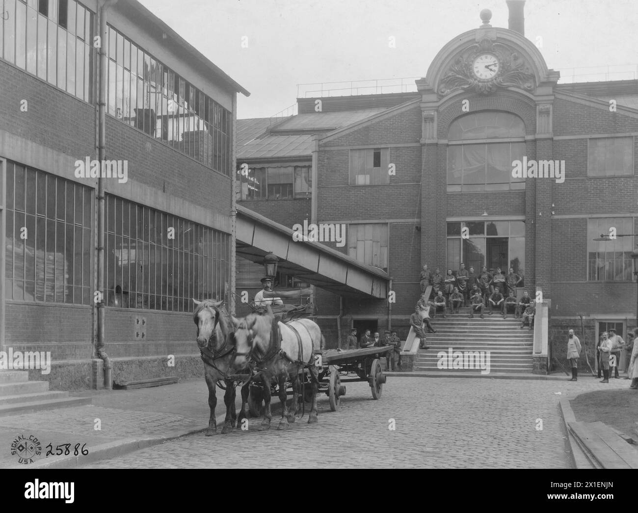 Main building of the Societe Publications Perodiques printing plant in Paris France. American soldiers are on the steps and a horse drawn cart is in the foreground ca. 1918 Stock Photo