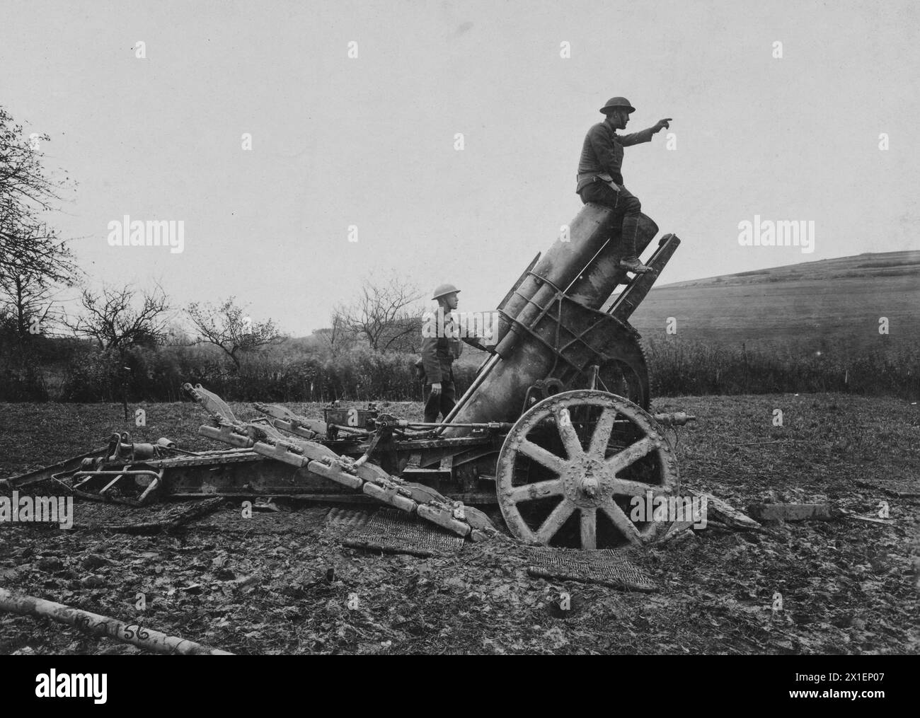 Original Caption: An American soldier sits atop a German 210 mm howitzer captured by the 80th Division; Near Vaux France ca. 1918 Stock Photo