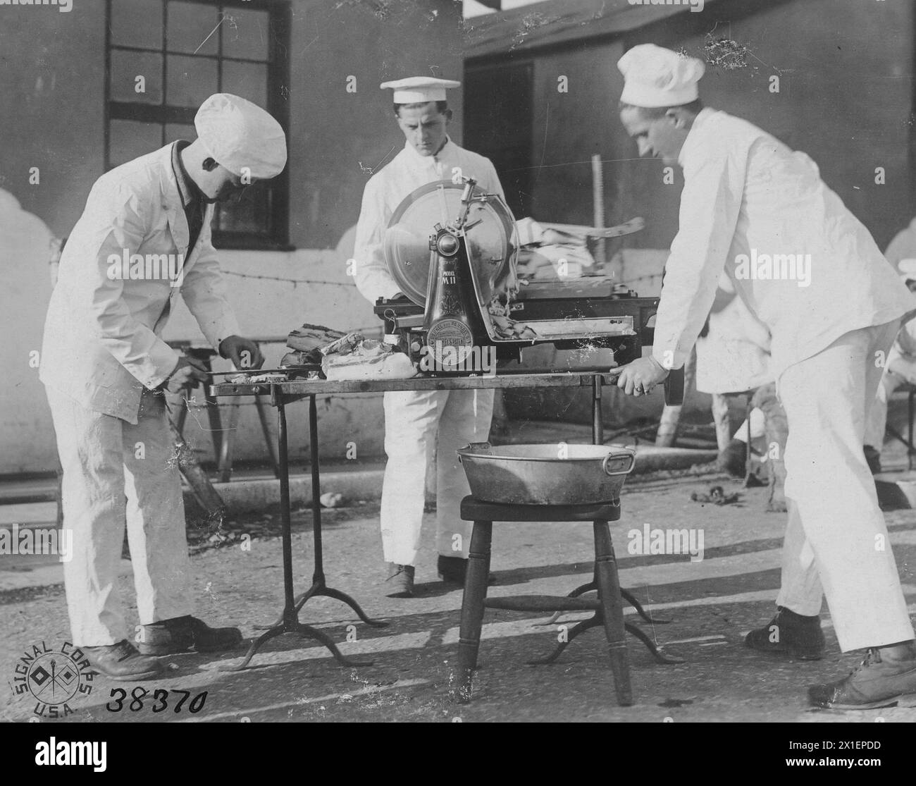 Men operating the headquarters troop mess bacon slicer at Winnal Down rest camp, Winchester, England ca. 1918 Stock Photo