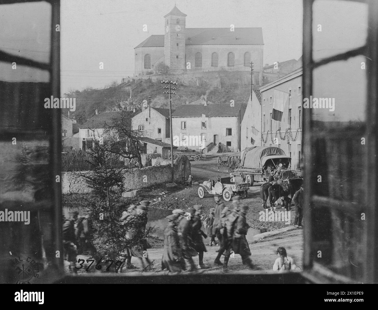 View through an attic window of machine gun company, 39th infantry, marching past a house Hettange Grande, France ca. 1918 Stock Photo