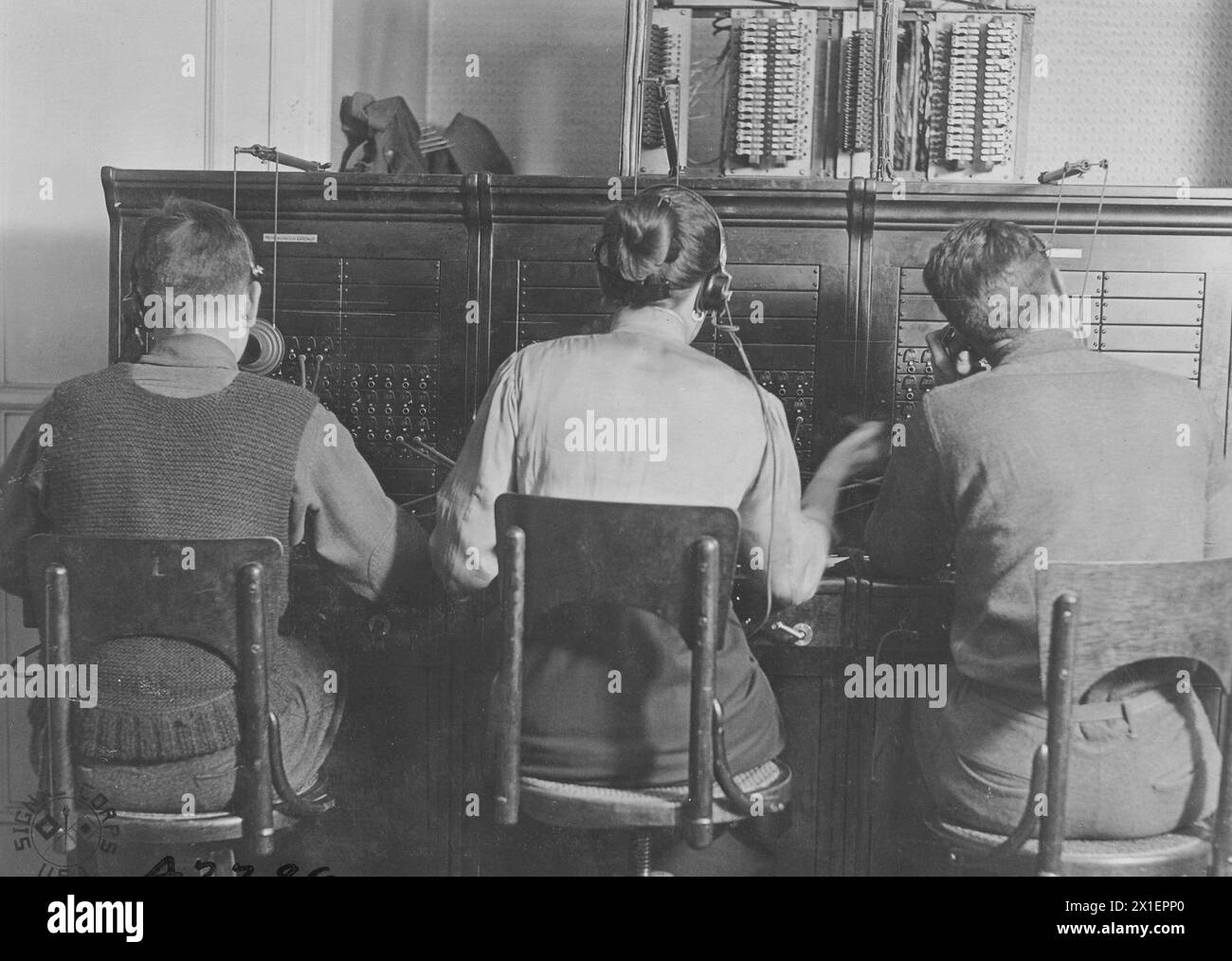 Two men and one woman work at a Magneto 3 Position telephone switchboard in Le Harvre France ca. 1918 Stock Photo