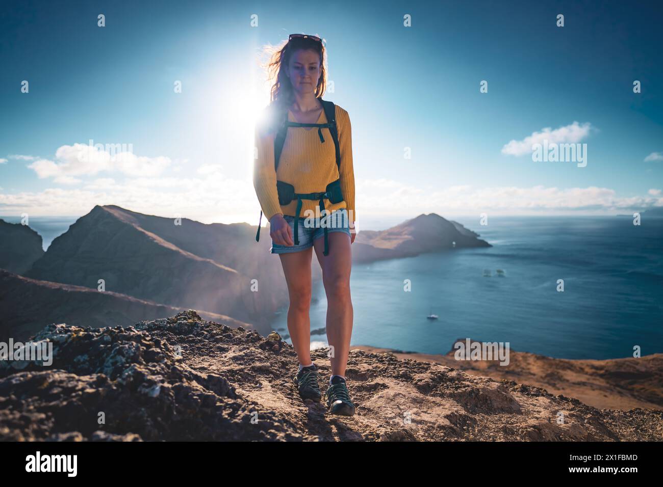 Backpacker Front Facing Description: Low angle front view of a tourist backpacker walking on ...