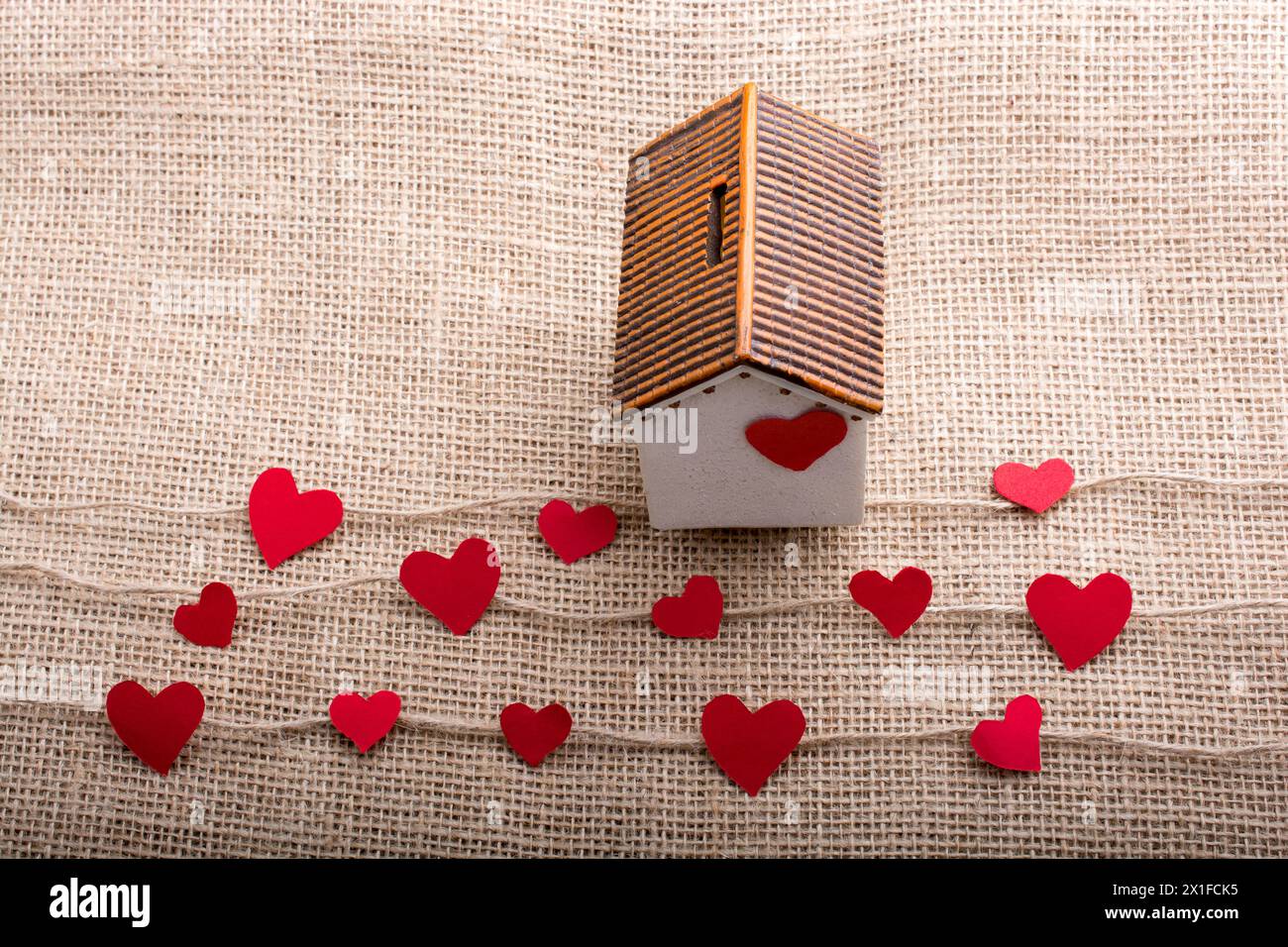 Heart shaped icons and paper house on linen threads Stock Photo - Alamy