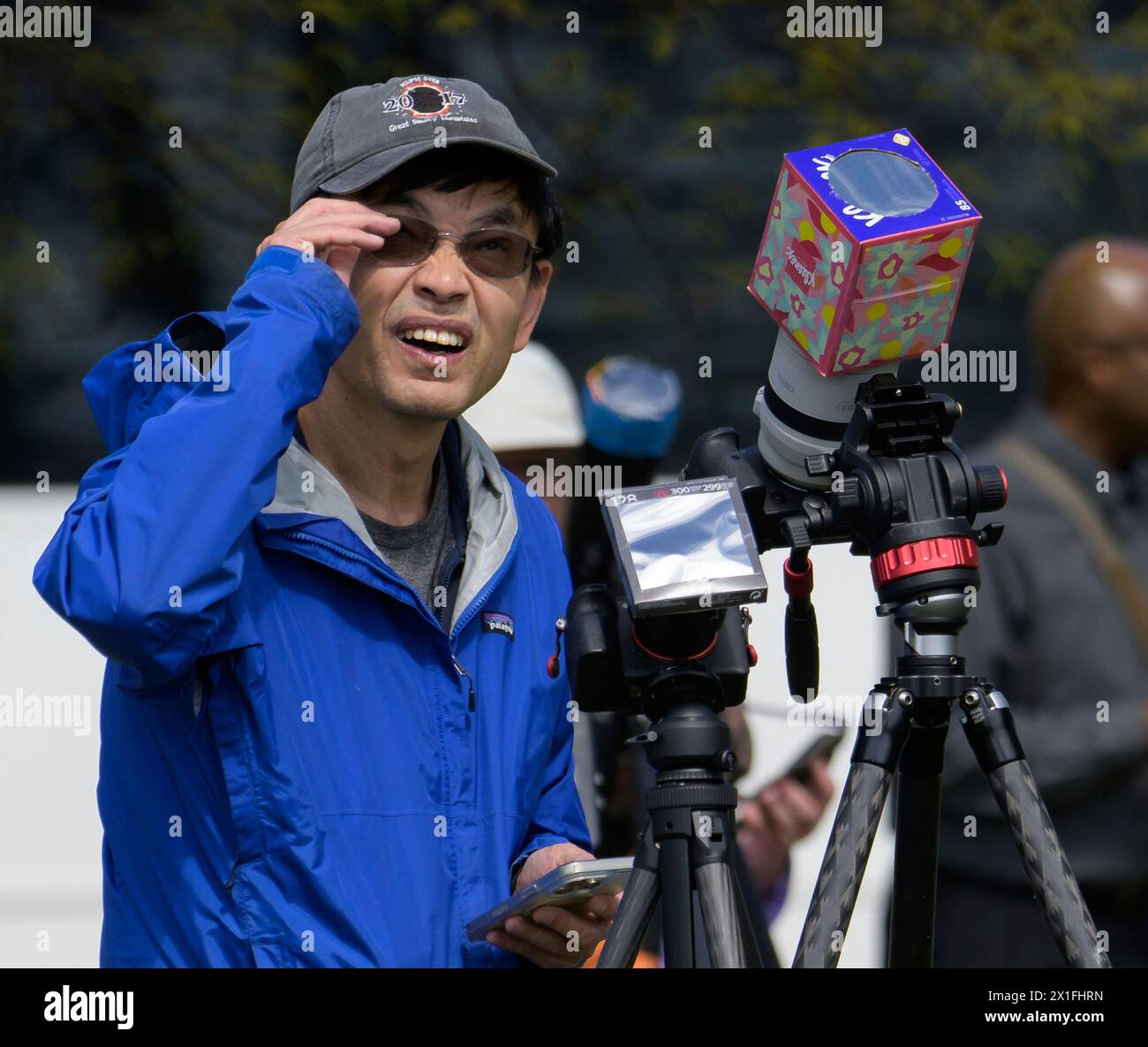 Editorial use only Man watching and recording the partial solar eclipse