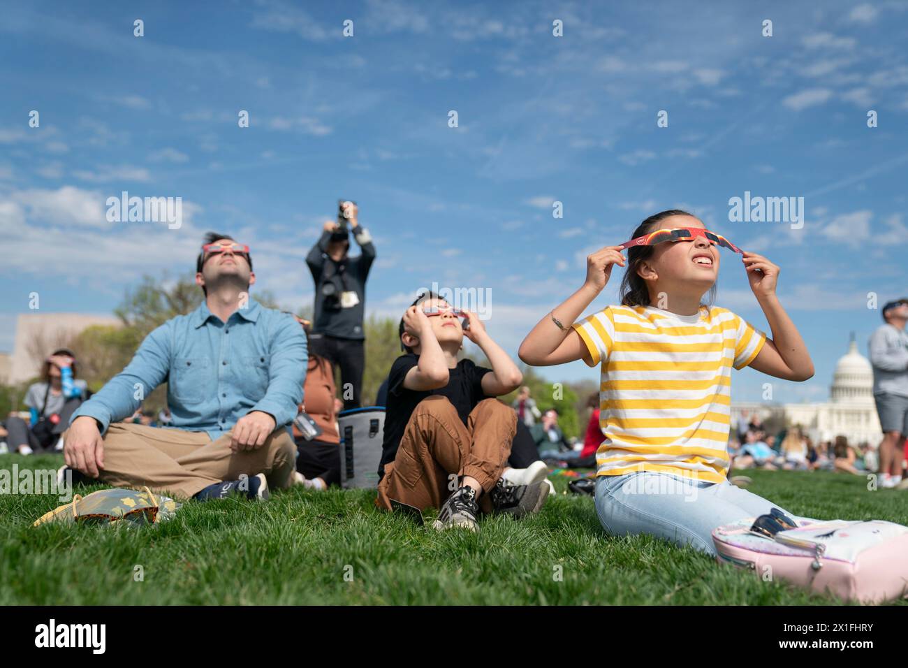 Editorial use only Family wearing eclipse glasses to watch the partial