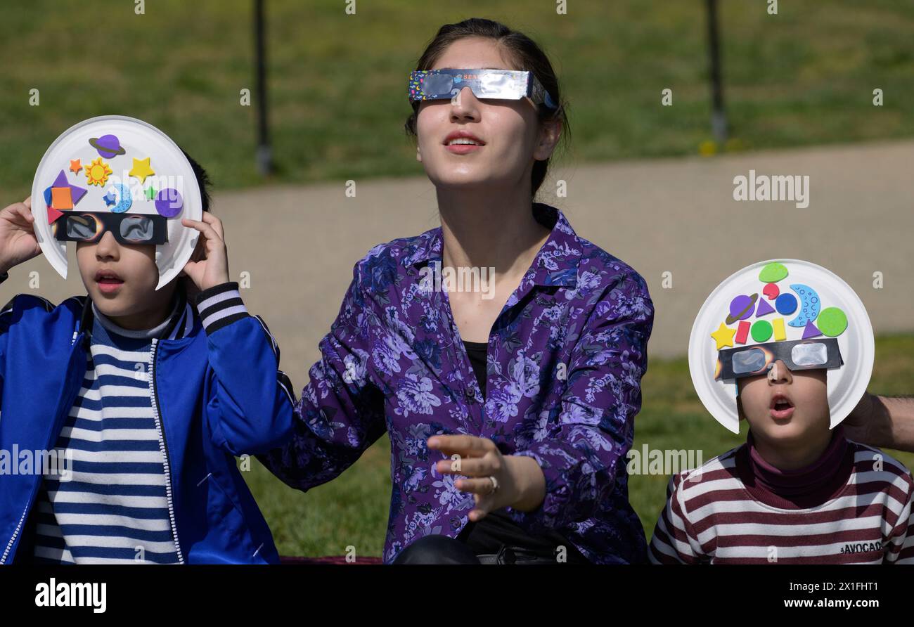 Editorial use only Family wearing eclipse glasses to watch the partial