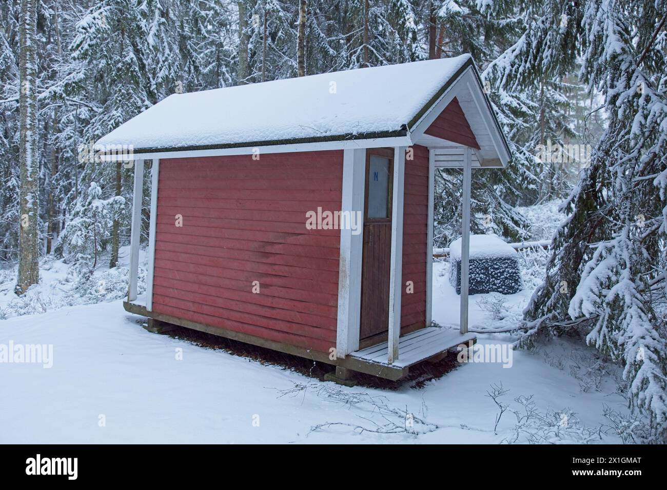 Snow covered wooden outhouse at Vetokannas in cloudy winter weather, Porkkalanniemi, Kirkkonummi, Finland. Stock Photo