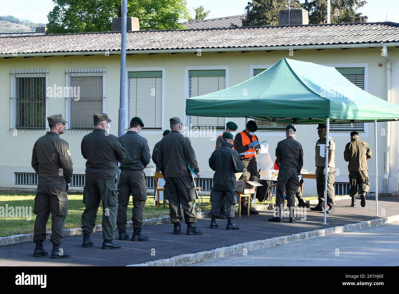 Austrian armed forces soldiers wear face masks as they line up at the