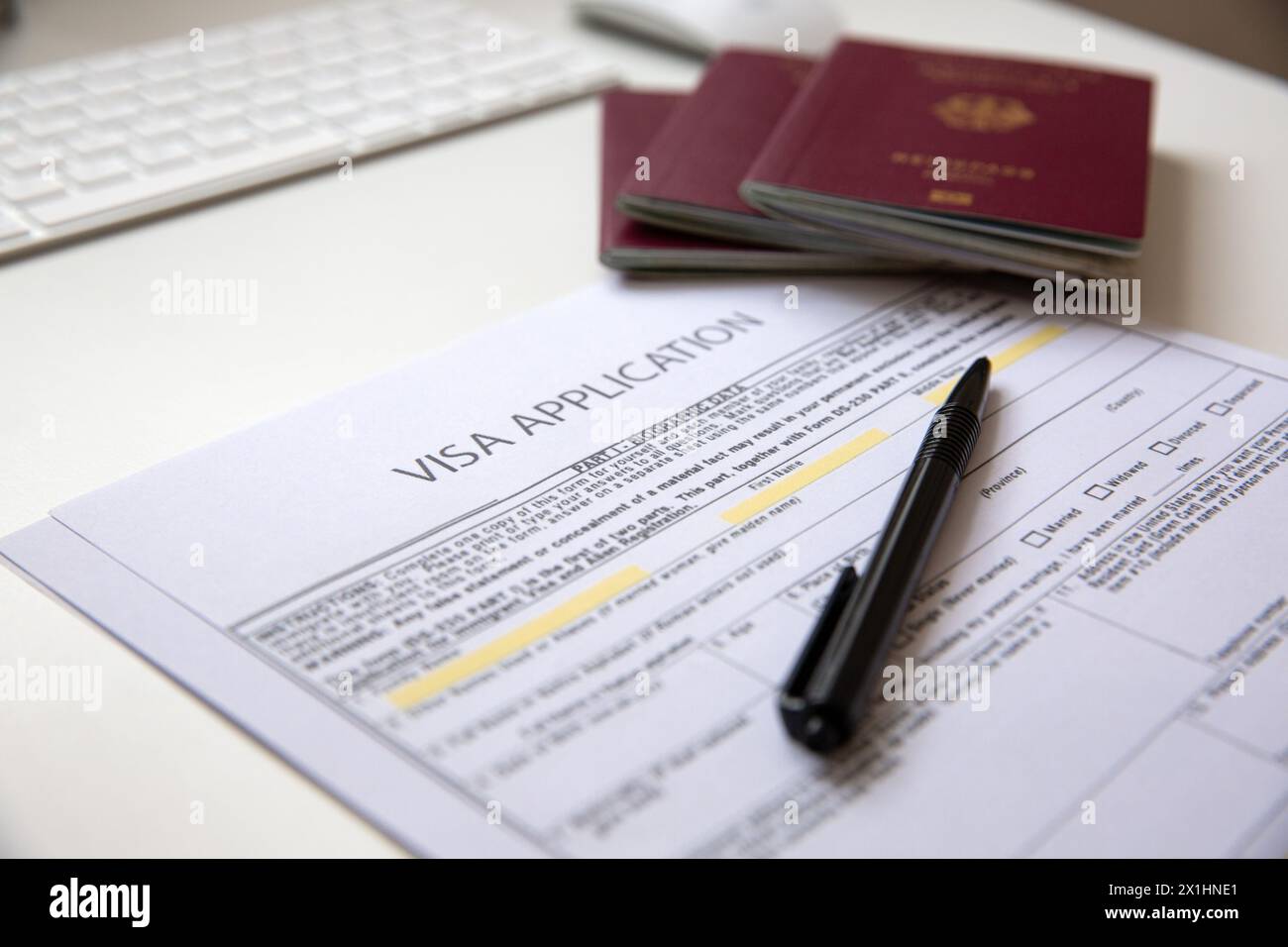 Close up of a visa application document with a German passport on table Stock Photo