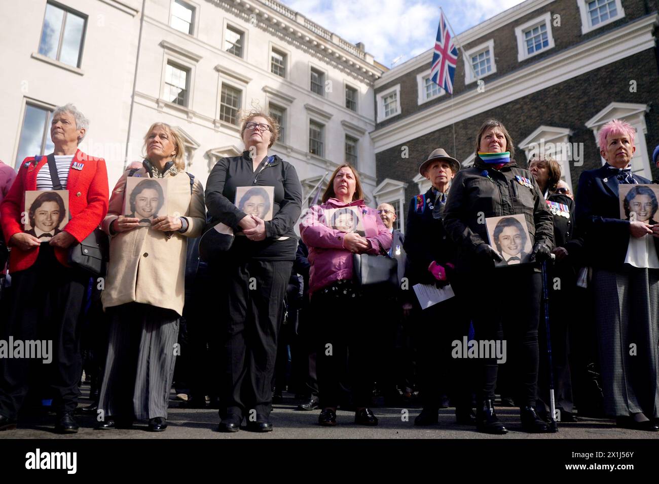 Colleagues of Pc Yvonne Fletcher hold photos of her as they gather in St James's Square, London, for a 40th anniversary memorial service. Pc Fletcher was murdered on 17 April 1984 by a shot fired from the Libyan embassy in St James's Square, London, after she had been deployed to monitor a demonstration against the then Libyan leader Muammar Gaddafi. Picture date: Wednesday April 17, 2024. Stock Photo