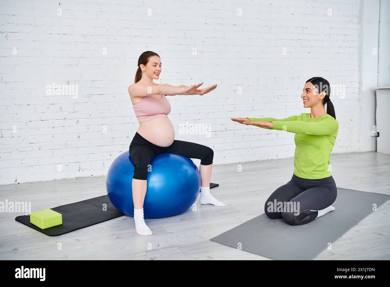 pregnant woman, guided by her coach, perform exercises on exercise