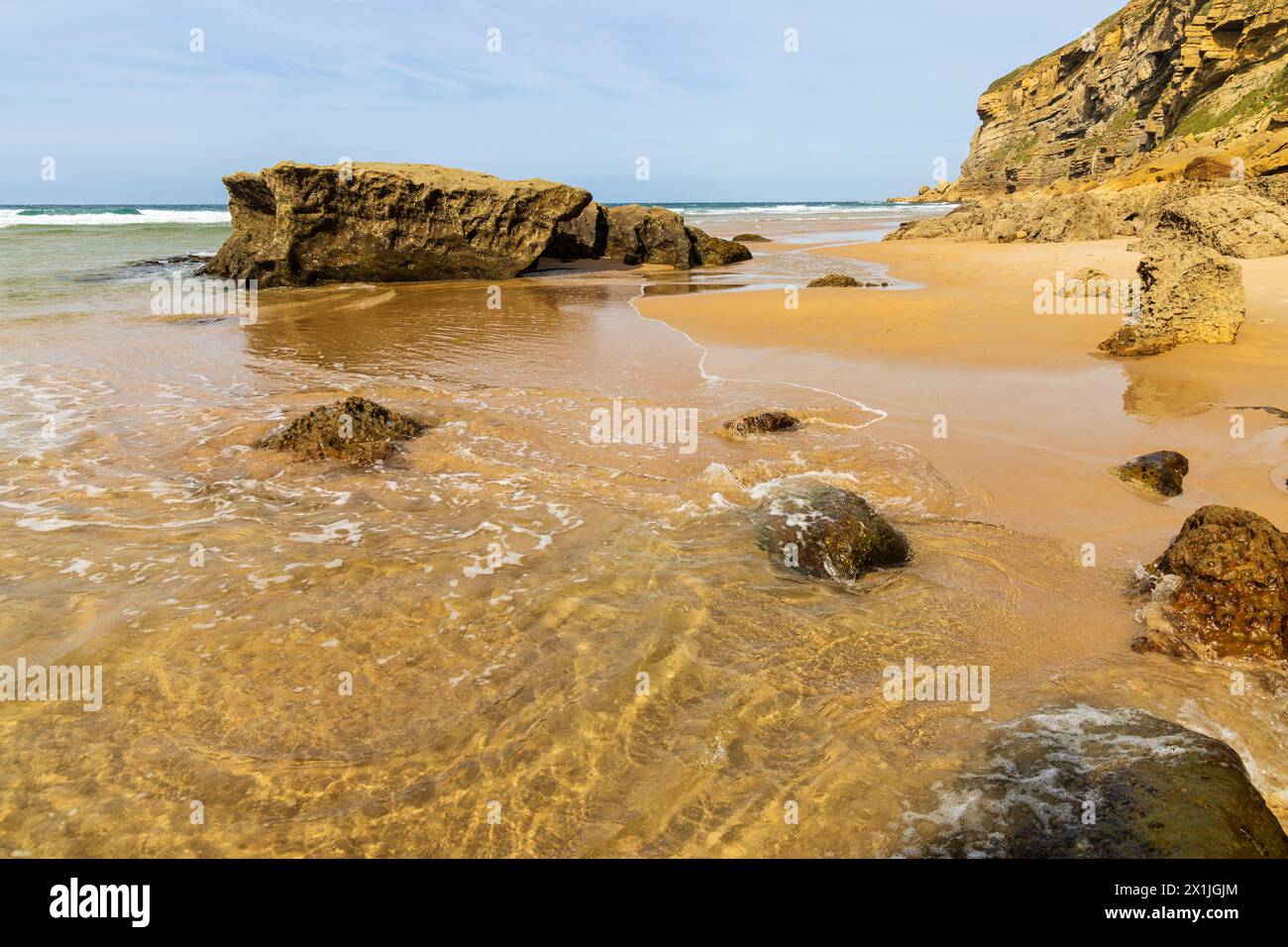 Luaña beach with golden sand, rocks, the Cantabrian Sea and cliff. Municipality of Alfoz de Lloredo, Cantabria, Spain. Stock Photo