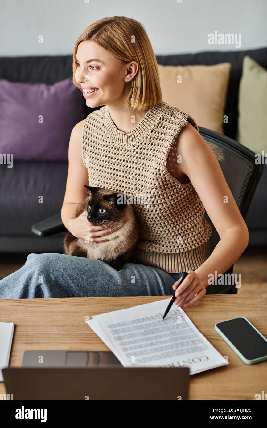 A woman with short hair relaxes on a couch, blissfully holding her cat in her arms, enjoying a quiet moment at home. Stock Photo
