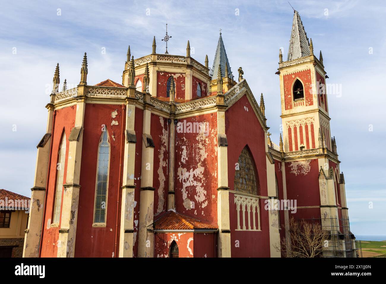 The bright red Parish Church of San Pedro Ad Venceya, with two towers, in the French Neo-Gothic and the Indiano. Cóbreces, Cantabria, Spain. Stock Photo